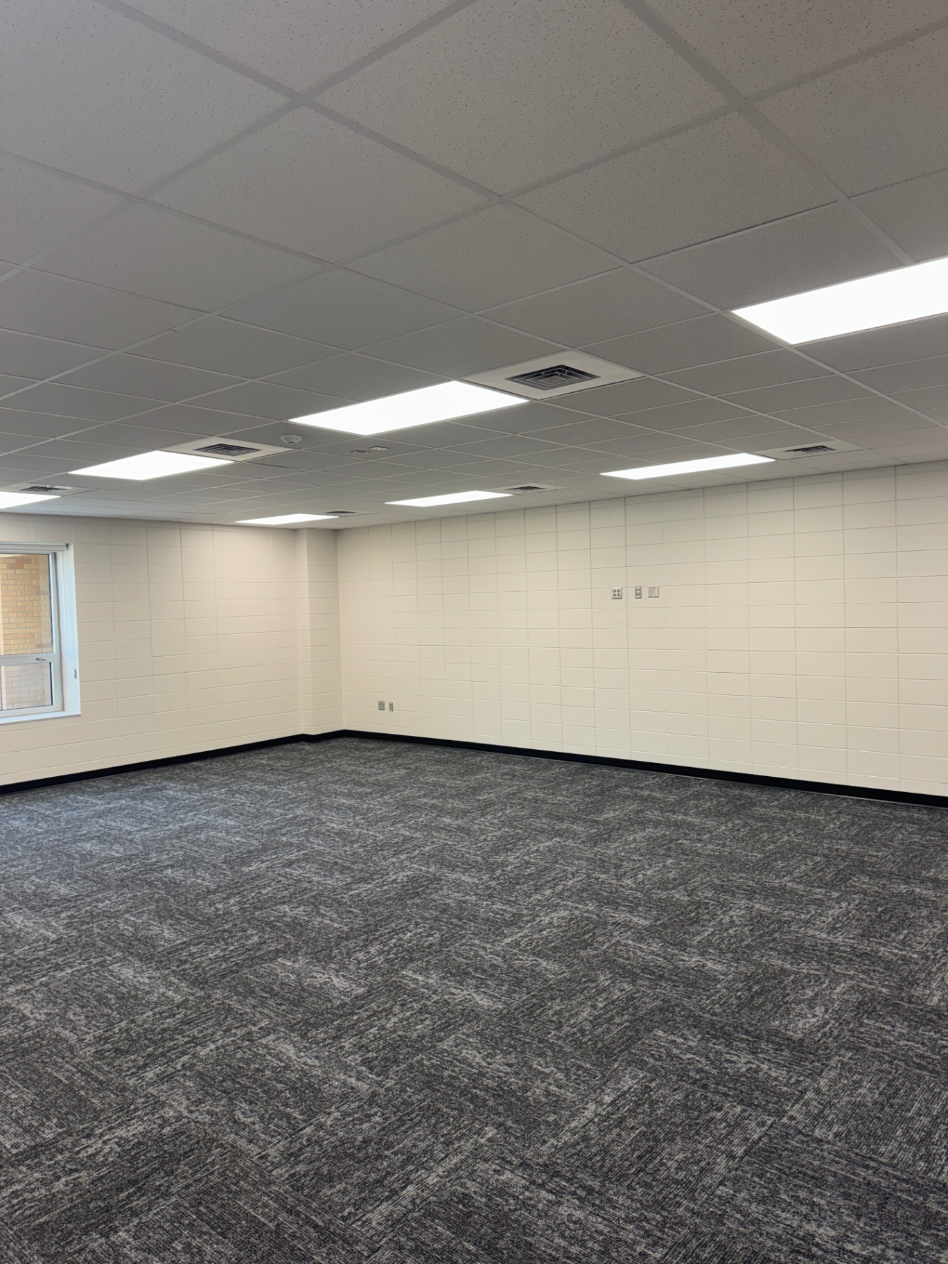 Finished room with ceiling panel lights and carpet