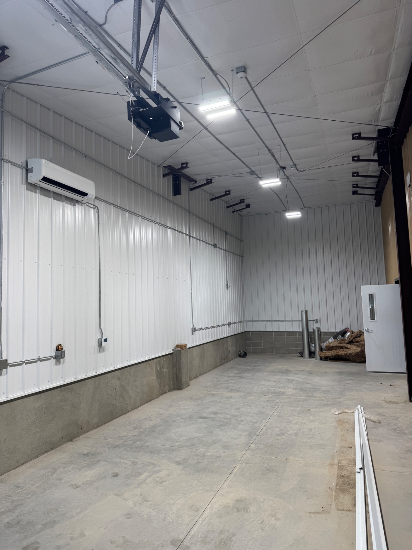 Overhead lighting and electrical conduit in a garage bay